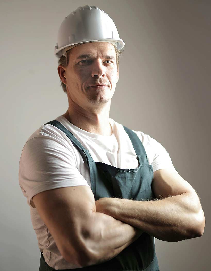 Man Using Measuring Tape in Factory Setting Man Using Measuring Tape in Factory Setting